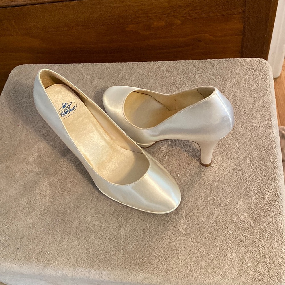 White satin pump 9M. The shoe has a round toe small platform and a 3 inch heel.